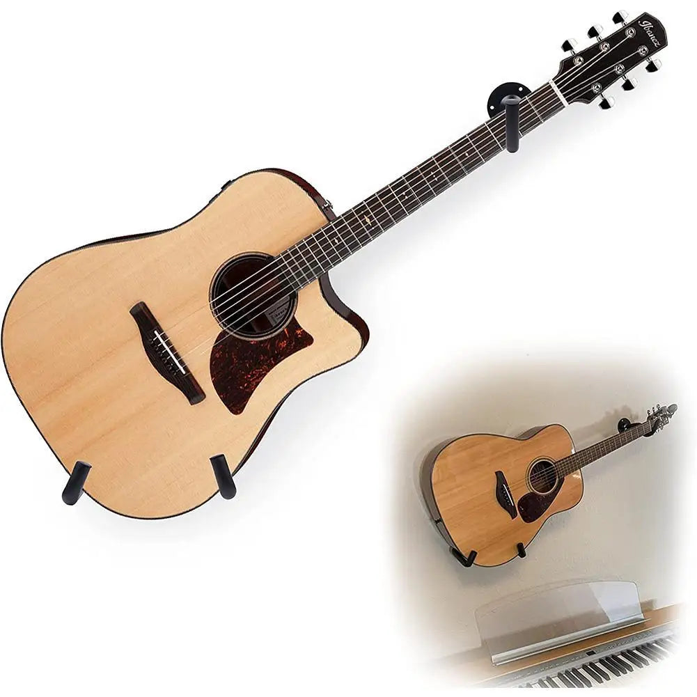 A light wood acoustic guitar is shown with a black strap and a wall mount hanger.