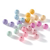 A collection of matte acrylic round beads in various pastel colors including blue, yellow, pink, and purple scattered on a wh