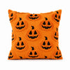 Orange knitted pillow covers featuring a repeating pattern of black jack-o'-lantern faces