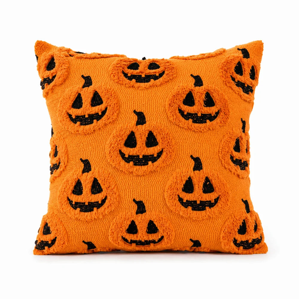 Orange knitted pillow covers featuring a repeating pattern of black jack-o'-lantern faces