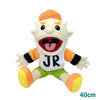 A realistic plush hand puppet resembling a character with orange hair and white teeth wearing a white shirt and green shorts.