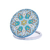 A folding mirror with a blue and gold floral design on the cover.