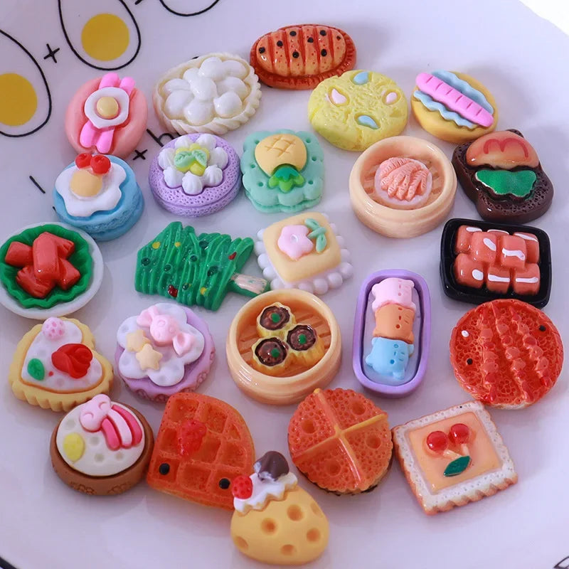 A collection of colorful miniature dollhouse snack foods including candies, jellies, and pastries arranged on a white surface