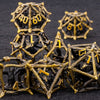 A set of black metal dice shaped like dragons, featuring gold accents, arranged on a dark surface.