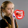 A young girl is using a red and purple toy megaphone designed to look like an open mouth for a fun voice-changing game.