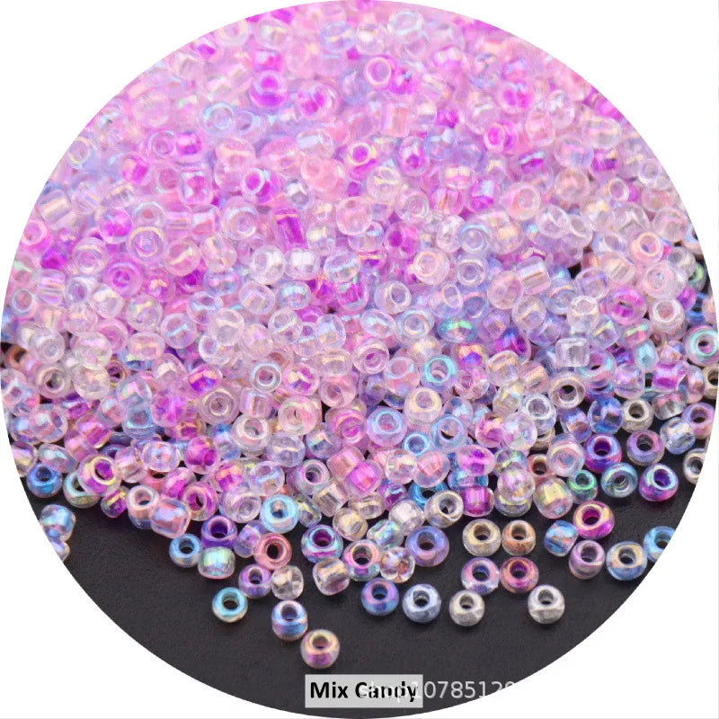 A pile of colorful round loose glass seed beads in various shades of pink and purple for jewelry making