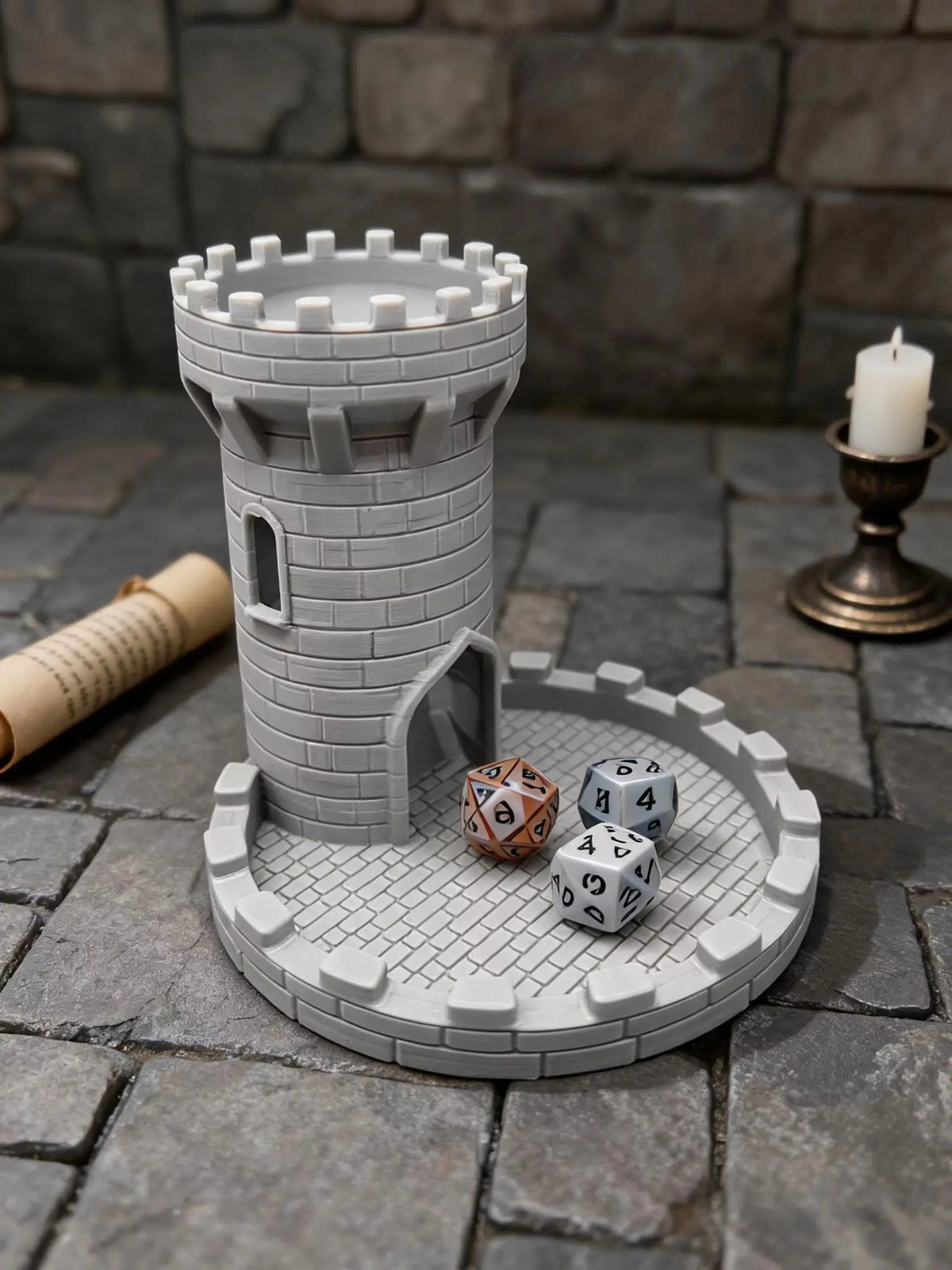 A gray medieval castle dice tower with a tray holding several polyhedral dice on a stone surface.