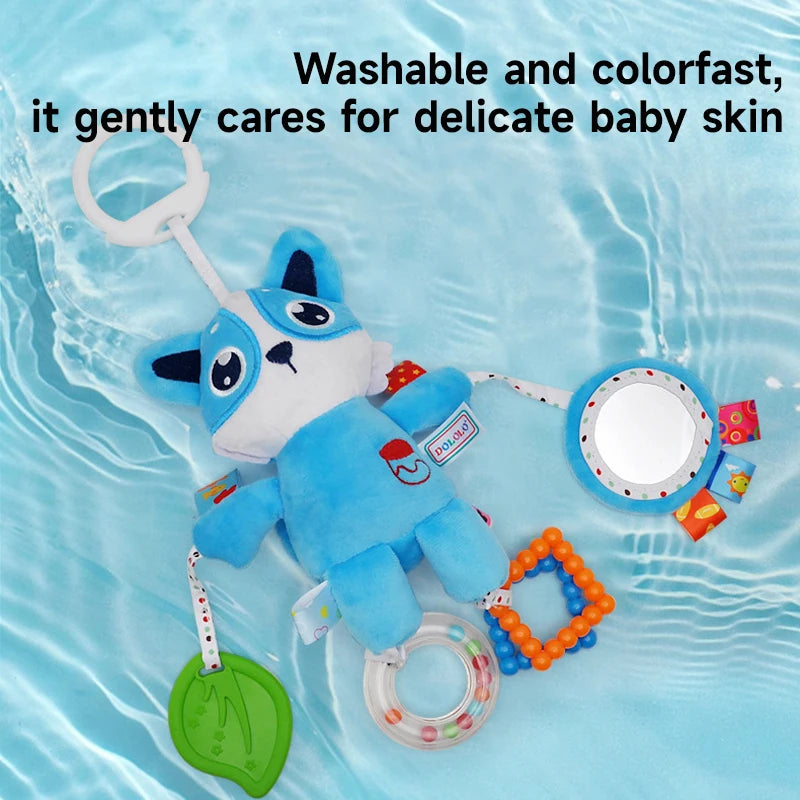 A blue plush toy with a white nose and ears is shown floating in water, attached to a ring and rattle toys.