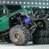 A green RC crawler vehicle with blue shock absorbers and large tires on a white surface.