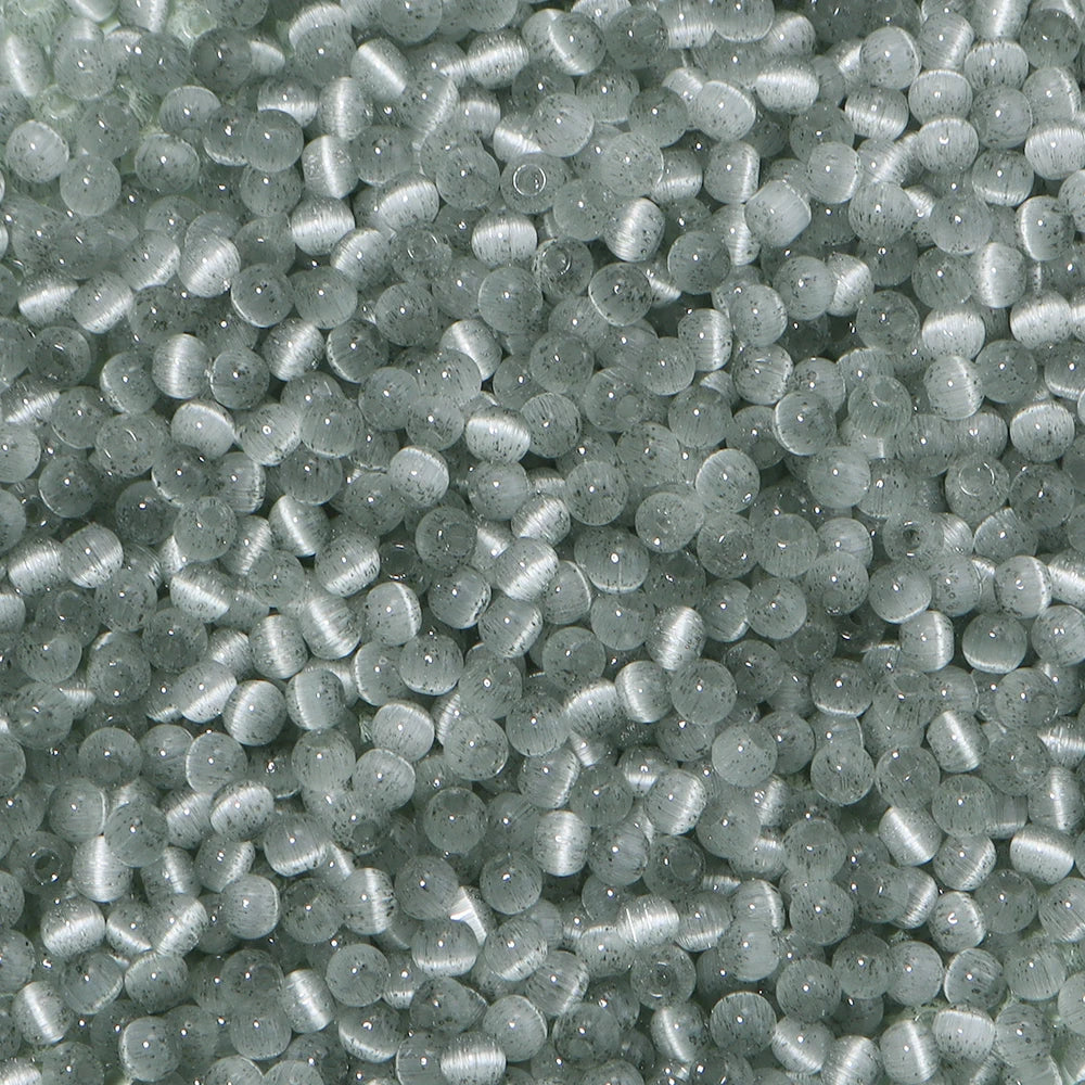 A close-up view of a mix of small, iridescent gray glass beads for jewelry making.