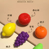 A collection of colorful fruit shapes, including a red tomato, yellow lemon, purple grapes, orange citrus, and green lime, us