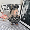 A plush Labubu doll wearing a black and gray flannel outfit with a bow, set against a black and white background.