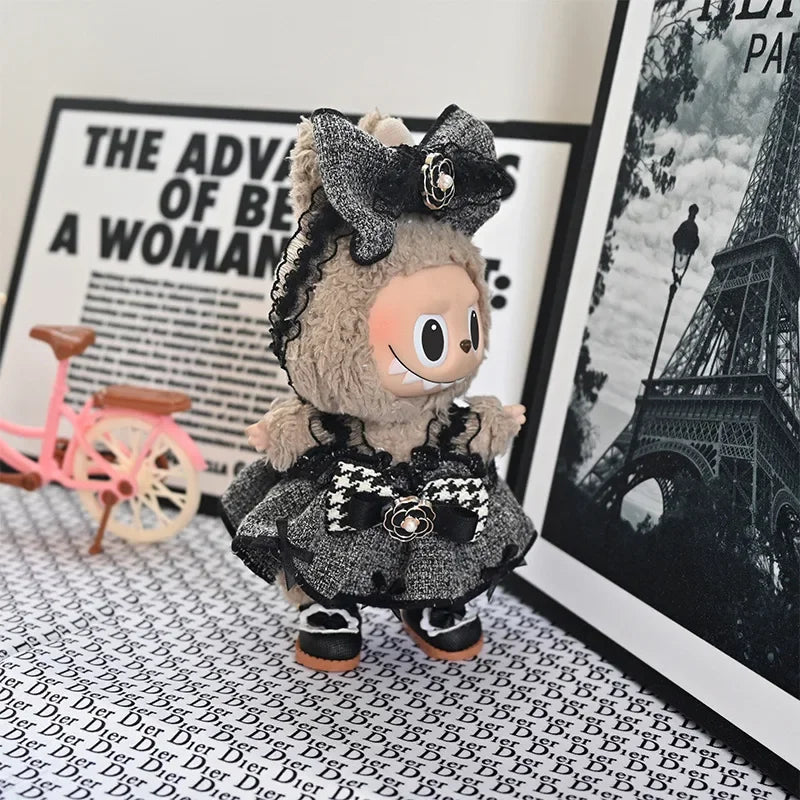 A plush Labubu doll wearing a black and gray flannel outfit with a bow, set against a black and white background.