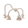 A light beige silicone teether ring with a curved handle and a looped end is shown against a white background.