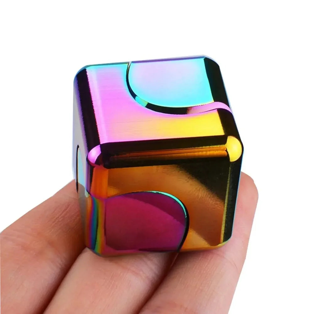 Un cube jouet anti-stress en alliage iridescent et brillant tenu dans la main d'une personne.