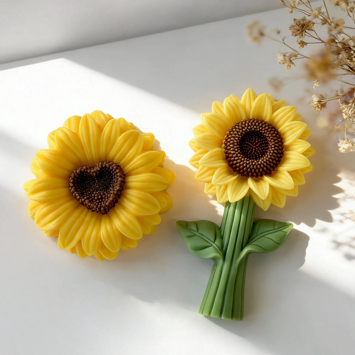 A bright yellow reusable sunflower silicone mold with a dark center and green stem and leaves.