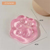 A pink squishy toy shaped like a cat paw, featuring small glitter particles.