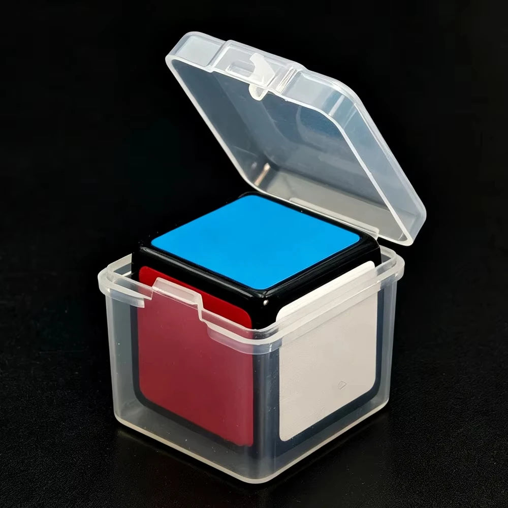 A clear plastic box with an open lid containing a blue cube and a red piece.