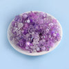 A pile of purple and lilac acrylic beads for DIY jewelry making