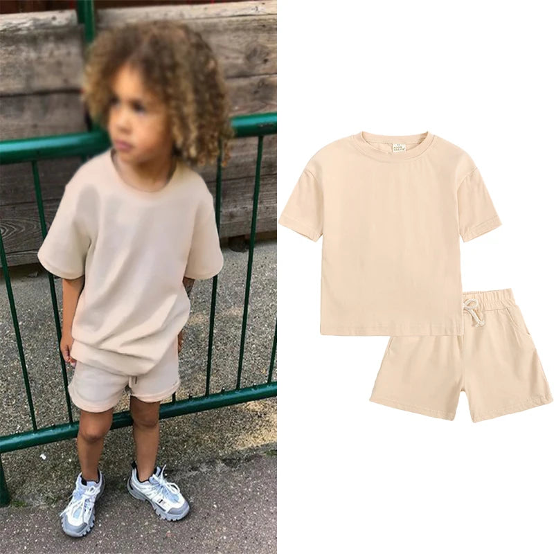 A light beige kids summer tracksuit set featuring a short sleeve top and matching shorts.