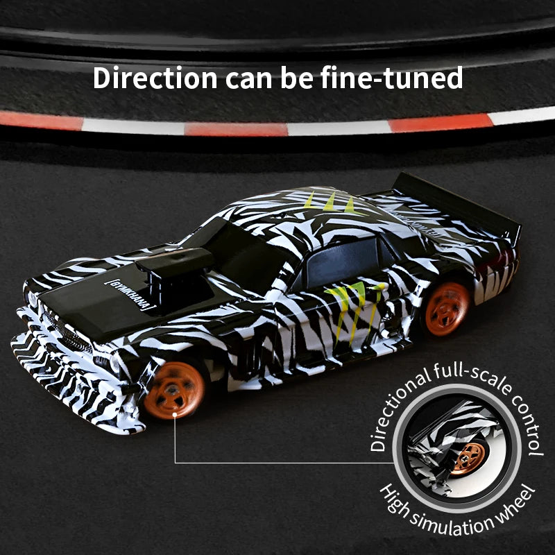 A black and white patterned mini RC drift car is shown with a full-scale directional control wheel.