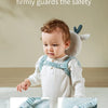 A baby wearing a white outfit with blue lateral reinforcement straps, demonstrating the safety of the product.