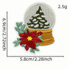 A hand-stitched patch featuring a green Christmas tree and a red flower on a yellow background.