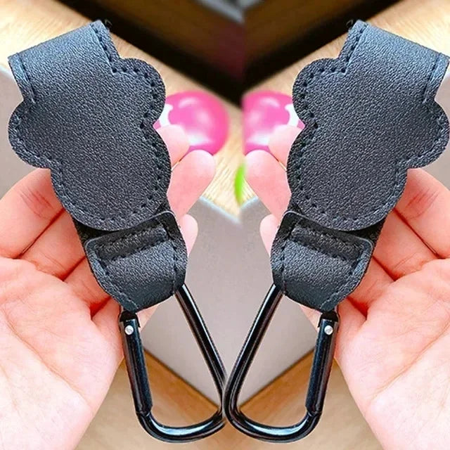 Black PU leather stroller organizer hooks with metal clasps shown in a hand.