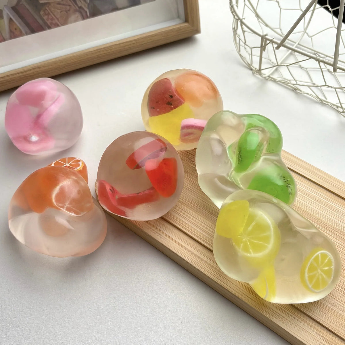A collection of translucent squishy stress balls shaped like various fruits, including watermelon, peach, and lemon.