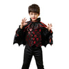 A young boy wearing a black vampire bat costume set with a cape and accessories.