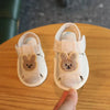 A pair of light pink soft sole first walker shoes for babies with embroidered bear ears