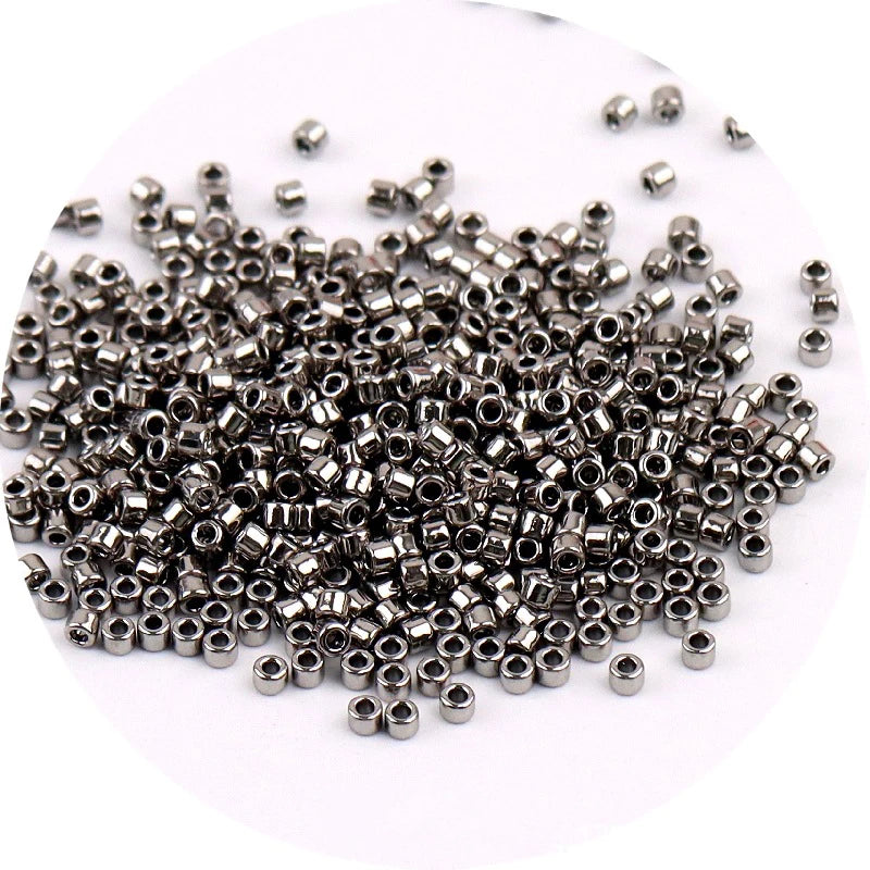 A pile of small, silver metallic glass beads for jewelry making.