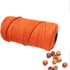 A spool of bright orange natural cotton macrame rope for crafts and decor.
