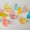 A collection of small, glow-in-the-dark animal figures in various colors like yellow, pink, and blue.