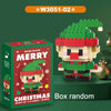 A box of Christmas micro building blocks featuring a Santa figure and reindeer, displayed on a green surface.