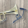 A gold-colored clip-on condenser microphone with a gooseneck attached to an acoustic instrument.