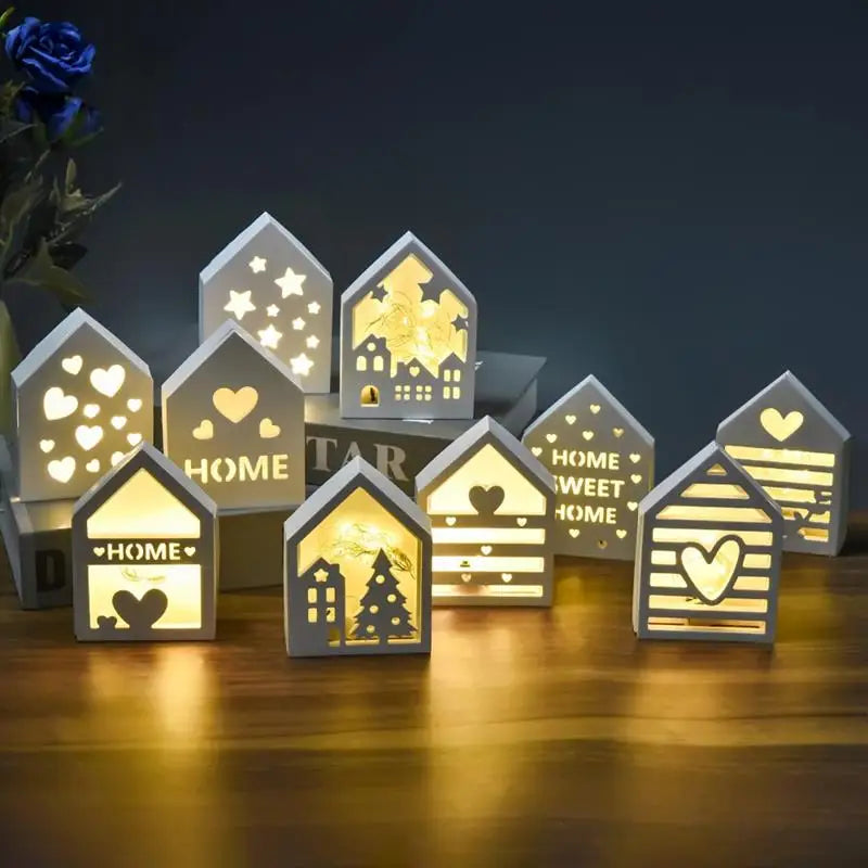 A collection of glowing white silicone molds shaped like houses featuring stars, hearts, and Christmas trees.