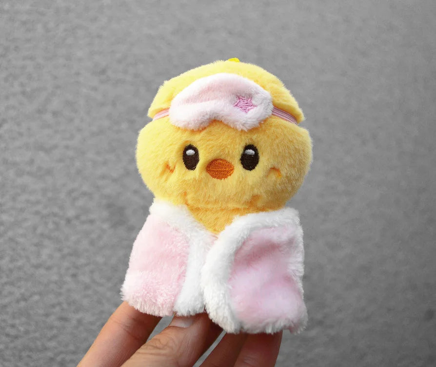 A yellow cartoon animal plush toy with pink accents and a light pink bag charm attached.