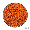 A pile of small, orange, cylindrical fuse beads for a craft kit.