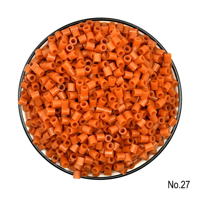 A pile of small, orange, cylindrical fuse beads for a craft kit.