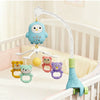 A light blue owl mobile with a white curved arm hanging over a crib, featuring several animal-shaped charms.