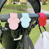 Three pink, mint green, and red Mickey Mouse-shaped PU leather organizer hooks hanging from a stroller bar.