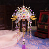 A detailed 3D metal phoenix crown model kit with colorful jewels and feathers displayed on a purple fabric.