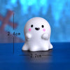 A white, chubby cartoon pumpkin bear figurine with black eyes and pink cheeks, shown against a blue background.