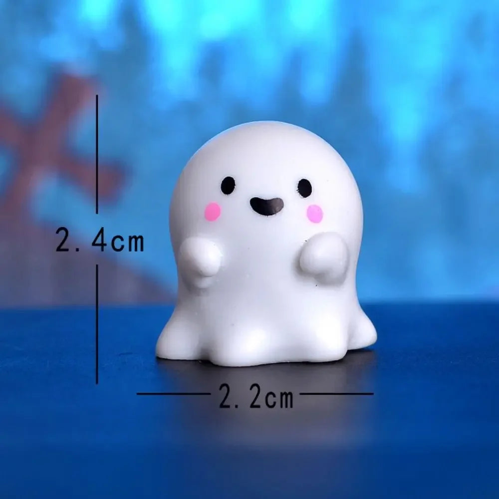 A white, chubby cartoon pumpkin bear figurine with black eyes and pink cheeks, shown against a blue background.