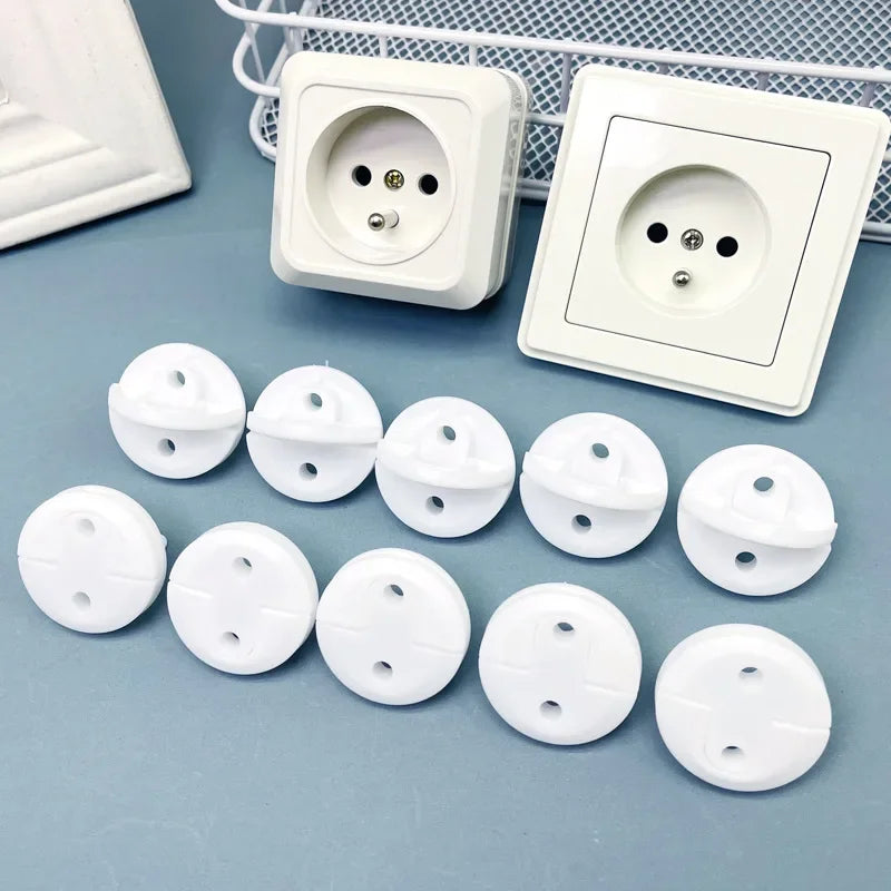 A white pack of six rotating socket safety covers for baby proofing displayed next to electrical outlets.