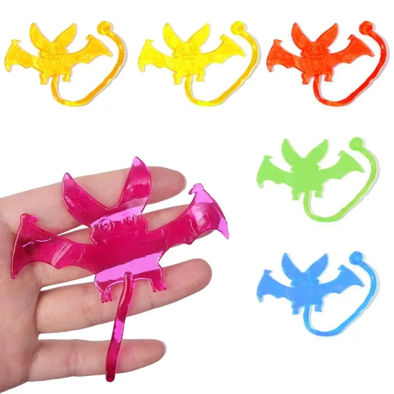 A set of colorful, stretchy, sticky climbing toys shaped like bats and spiders for Halloween party favors.