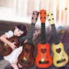 A set of four wooden toy guitars, including a ukulele-style guitar, displayed against a bright background.