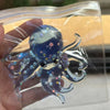 A clear plastic pouch contains a blue stretchable octopus stress ball with iridescent details and small stars.