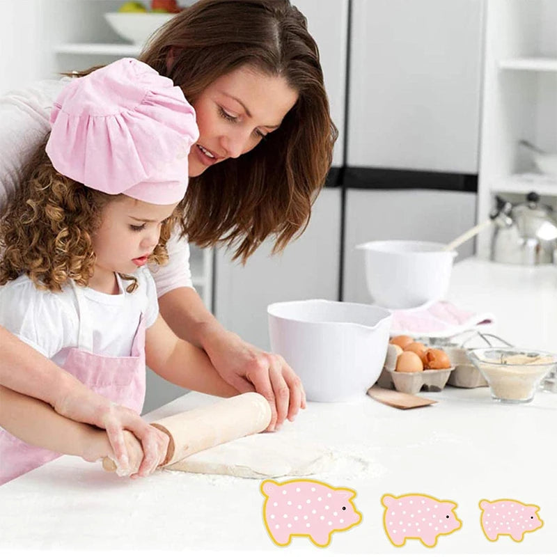 A woman is helping a child make cookies using a pig-shaped stainless steel cookie cutter set.